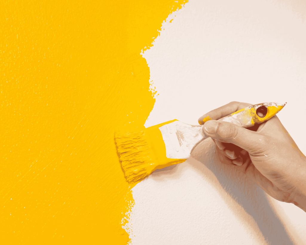 painting yellow on room wall with thin brush